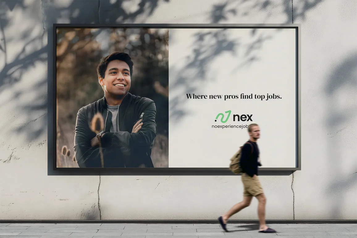 A man walks in front a billboard advertising No Experience Jobs on the side of a building.